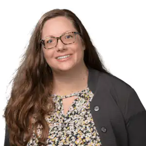 Professional headshot of Stephanie May, Closer at Morgan Financial, wearing glasses, a patterned top, and a dark cardigan.